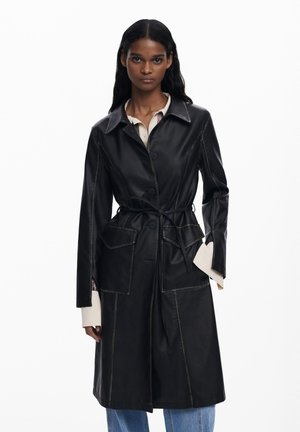 Black leather trench coat with a fitted design, button closure, front pockets, and a tied waist. Contrast stitching and long sleeves.