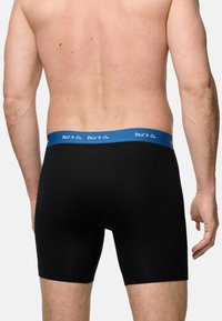 Svarta kalsonger med ett blårandigt elastiskt midjeband som har vit text. Designen är åtsittande, med en slät yta och är i knähöjd.