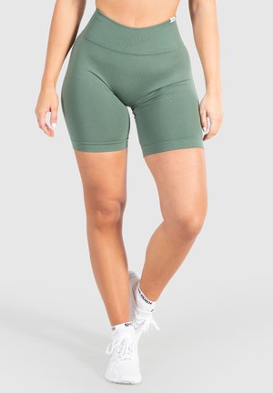 Groene high-waisted fietsbroek gemaakt van rekbaar materiaal, met een geribbelde structuur en een gladde afwerking. Geen zichtbare logo's of patronen.