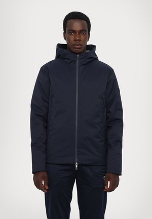 Giacca con cappuccio blu navy con chiusura a zip, dotata di tasche laterali e un tessuto liscio e isolante per mantenere caldo. Design semplice, vestibilità moderna.