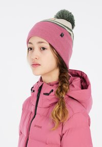 Cappello a maglia rosa con pompon verde, motivo a righe e etichetta con logo. Abbinato a un giubbotto imbottito rosa con colletto alto.