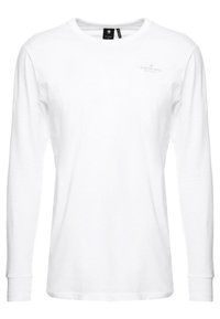 Långärmad vit t-shirt i bomull, med rundad halsringning, vanlig passform och en diskret logodetalj på bröstet.