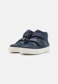 Sneaker alte di colore blu scuro con finitura lucida, dotate di due cinturini in velcro, dettagli testurizzati e suola in gomma bianca.