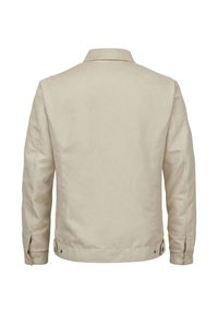 Helle beigefarbene Jacke mit Kragen, langen Ärmeln und Druckknöpfen am Saum, aus einem glatten, strukturierten Stoff.