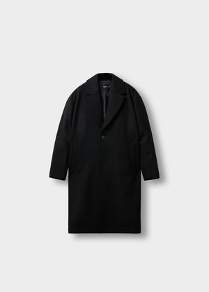 Cappotto in lana nera con colletto a punta, chiusura con un bottone singolo e tasche laterali. Presenta una linea dritta e una finitura texturizzata.