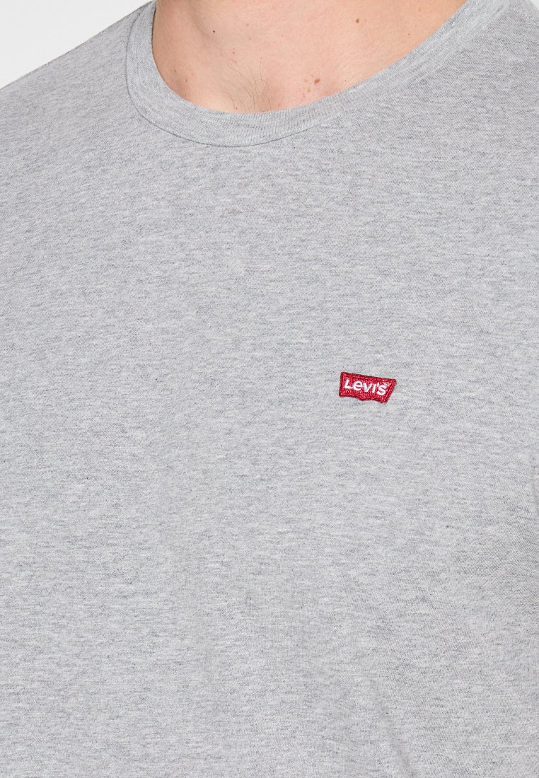 Szara bawełniana koszulka z okrągłym dekoltem, z małym czerwonym logo Levi's na piersi. Gładka tekstura, krótkie rękawy, standardowy krój.