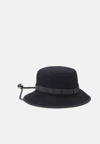 Sombrero de cubo negro hecho de tela texturizada, con un ala ancha, corredera ajustable y banda suave alrededor de la parte superior. Diseño ligero.