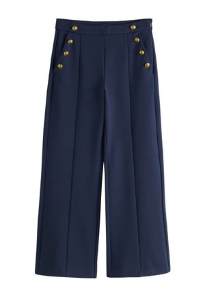 Tmavomodré nohavice širokého strihu s vysokým pásom a dvoma radmi po šesť zlatých gombíkov na predných vreckách.
