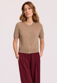 Beżowy kardigan krótki z rękawami, o okrągłym dekolcie, z dekoracyjnymi guzikami i prążkowanym wykończeniem, stylizowany z bordowymi, szerokimi spodniami.
