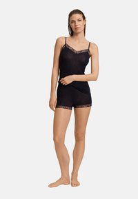 Svart topp och shorts-set med spetsdetaljer. Mjukt tyg, tunna band, figurnära design och intrikata spetsdetaljer vid halsringning och fåll.