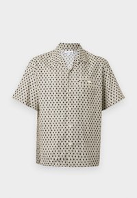 Korte mouwen button-up shirt in beige met een geometrisch zwart en crème patroon. Heeft een kraag en een borstzakdetail.
