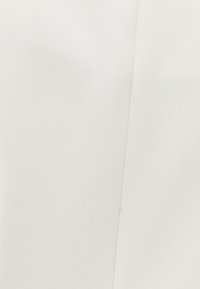 Tessuto bianco con una superficie liscia e una leggera lucentezza, caratterizzato da una cucitura lungo un lato.
