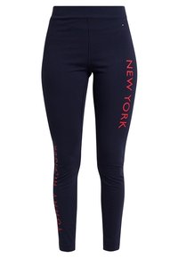 Leggings navy en matière extensible avec du texte rouge "NEW YORK" et "TOMMY HILFIGER" sur les côtés. Design slim-fit.