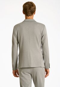 Blazer ajustado de color gris claro, confeccionado con una tela suave. Presenta un clásico cuello con muesca, una abertura en la parte posterior y puños con botones.