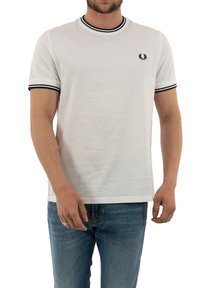 White cotton t-shirt with black ribbed collar and sleeve cuffs, featuring a small black embroidered logo on the chest and a relaxed fit.