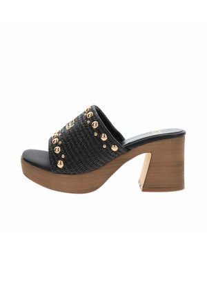 Mule nero intrecciato con punta aperta, tacco a blocco in legno e borchie rotonde dorate che decorano la fascia superiore.