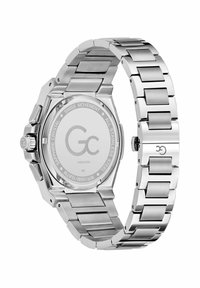 Hõbedane roostevabast terasest kell, millel on seotud käevõru, kaheksanurkne korpus ja minimalistlik kellanägu. Omab silmapaistvat kroonit ja logo taga.