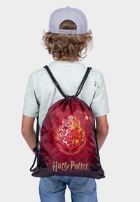 Zaino a sacco rosso e nero con cordoncino, decorato con il crest dorato di Hogwarts e il testo "Harry Potter"; realizzato in tessuto liscio con motivo a scacchi.