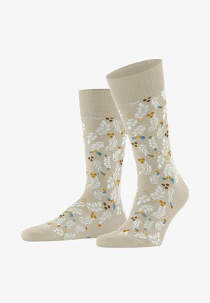 Chaussettes beige mi-mollet avec un motif floral en blanc, jaune, marron et feuilles bleues ainsi que de petites fleurs.