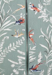 Blommig zip-up jacka i strukturerad mintgrön tyg. Designen inkluderar färgglada fåglar och blad samt en central metalldragkedja.