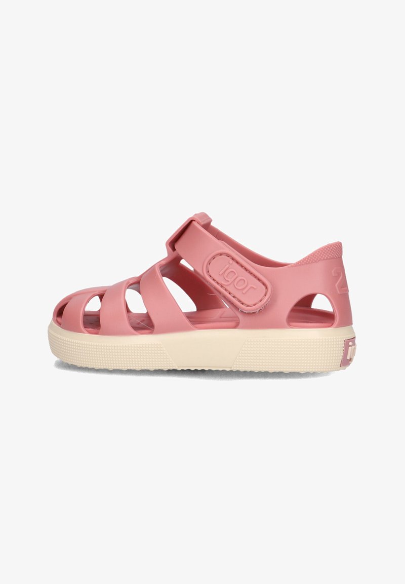 Pink plastic sandal with multiple cut-out straps, adjustable ankle strap, textured sole, and integrated logo on the side.