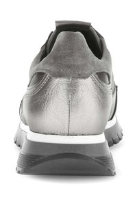 Grauer Sportschuh mit metallic-lederner Oberfläche, Wildlederelementen an der Ferse und einer weißen Zwischensohle mit einer strukturierten schwarzen Außensohle.