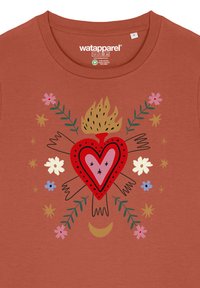 Rostfarbiges T-Shirt mit einem zentralen Herzdesign, Flammen, Blumen und blättrigen Akzenten. Es hat einen runden Halsausschnitt und kurze Ärmel.