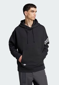 Černá mikina s kapucí, přední kapsou, šňůrkami na kapuci a třemi bílými pruhy na jednom rukávu. Vyrobena z měkké látky a má logo.