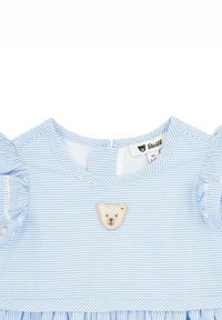 Robe rayée bleu clair avec des manches bouffantes, arborant un patch brodé en forme d'ours au niveau de la poitrine et un détail de ourlet froncé.