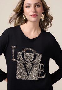 Maglietta nera a maniche lunghe con un design in paillettes argentate che forma la parola "LOVE". Scollo rotondo, texture liscia e vestibilità comoda.