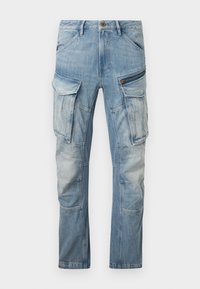 Light blue denim cargo pants with multiple pockets, including zippered and flap pockets on the thighs, and stitched panel details.