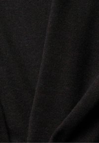 Tissu noir avec une texture fine et douce en maille, montré en gros plan avec des plis délicats et un éclairage subtil.