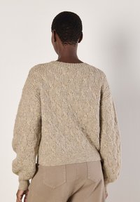 Beige gestrickter Pullover mit einem strukturierten Muster, runder Ausschnitt und elastischen Bündchen. Von hinten mit einer lockeren Passform präsentiert.