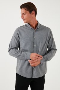 Grijze button-up shirt van stevige stof, lange mouwen, standaard kraag en ronde zoom. Voorzien van lichte knopen en een relaxte snit.