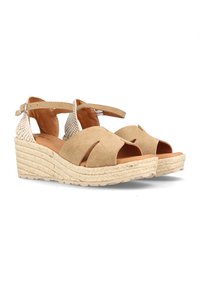 Sandalias de cuña de ante beige con dedos al aire, correas entrelazadas y suelas de esparto trenzado. Correa en el tobillo para un ajuste seguro. Paneles laterales texturizados.
