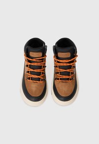 Bottines marron et noires avec semelles en caoutchouc, lacets oranges, accents en cuir et panneaux texturés. Comprend un logo de marque sur le côté.