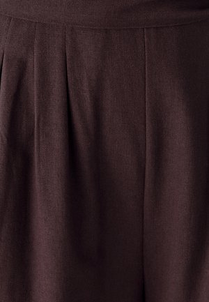 Tmavo hnedá, textúrovaná tkanina s plisovaním a hladkým pásom. Materiál má jemný povrch a zdá sa, že je prispôsobený pre elegantný vzhľad.