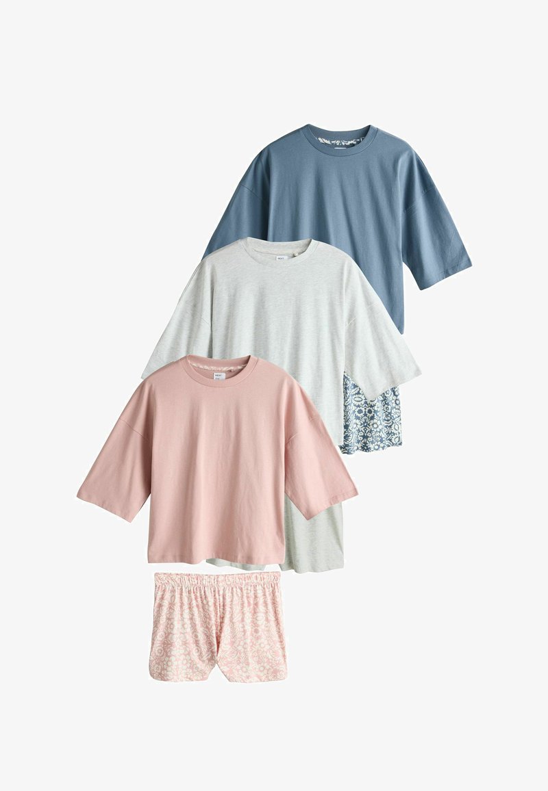 Trois hauts à manches courtes surdimensionnés en bleu, gris clair et rose, avec des shorts assortis à motifs floraux roses et bleus.