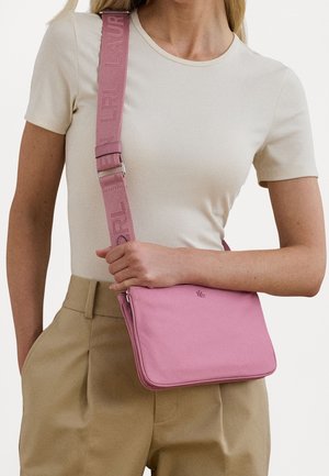 Roze schoudertas met een gladde textuur, voorzien van een logo op de voorkant en een brede, verstelbare band met reliëfbranding.