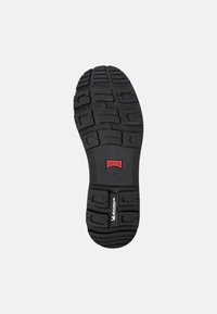 Musta kumisaapas, jossa on teksturoitu pito Musteri. Mukana on "CAMPER"-logo ja koko "42" sekä "MICHELIN"-brändäys.
