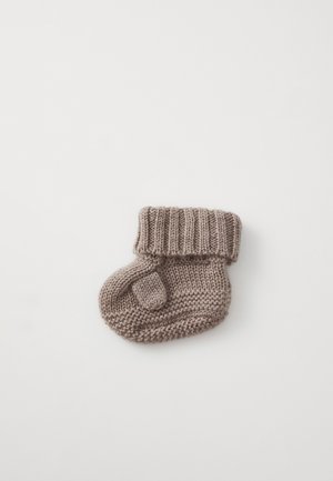 Mitaine de bébé tricotée en doux fil de couleur marron clair, avec un poignet côtelé et un détail au niveau du pouce, de forme arrondie et surface texturée.