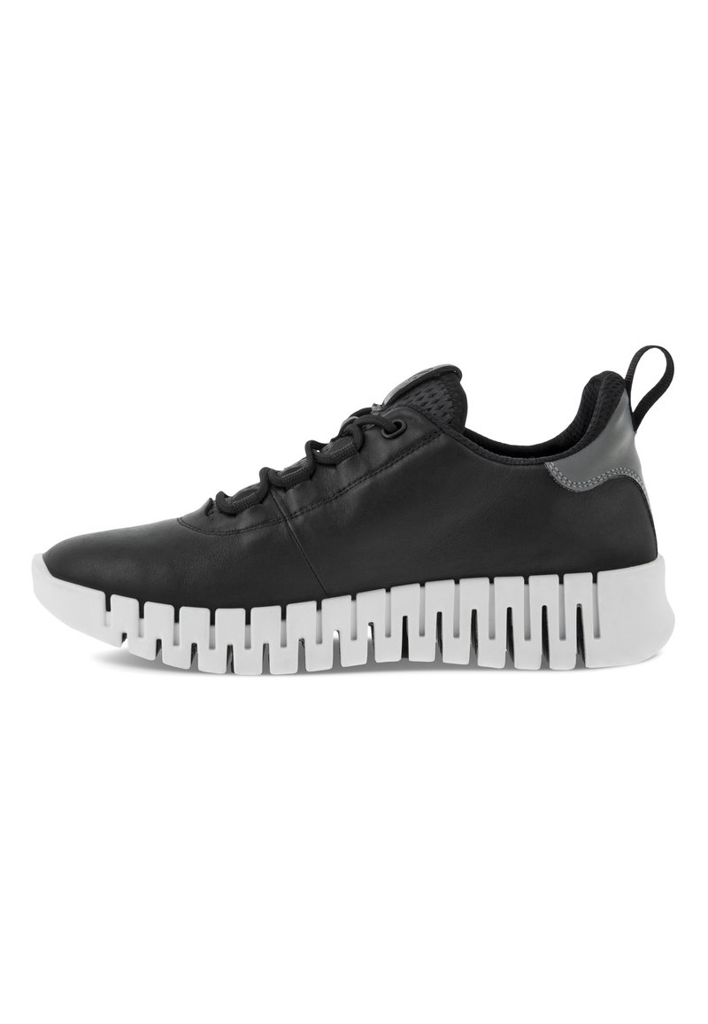 Svart lærsneaker med teksturert overdel, med en kraftig hvit gummisåle, avrundet tå og snøring front. Sølvdetalje på hælen.
