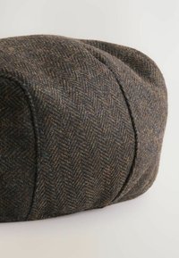 Kappe im Fischgrätmuster aus strukturiertem, dunkelbraunem Tweed, mit runder Form, gesteppten Akzenten und umgeschlagenem Rand.