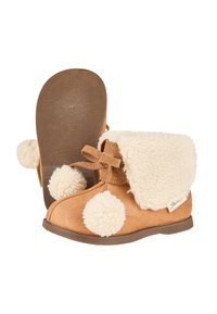 Braune Wildlederschuhe mit einem flauschigen, cremefarbenen Kunstfellbund, Pompons an der Seite und einer strukturierten Gummisohle für besseren Halt.