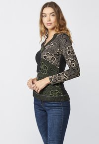 Schwarzer und grüner gemusterter Langarmpullover mit floralen Designs, strukturiertem Rippbündchen und V-Ausschnitt. Hergestellt aus Mischmaterialien.