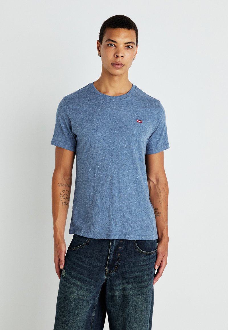 Μπλε μπλούζα με λαιμόκοψη και κοντά μανίκια, διαθέτοντας ένα μικρό κόκκινο λογότυπο της Levi's στη δεξιά πλευρά. Χαλαρή εφαρμογή.