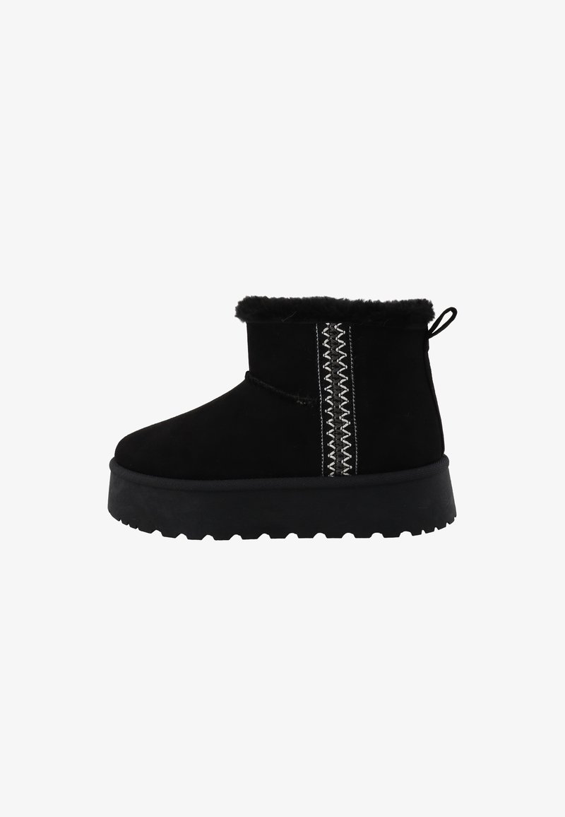 Bottine d'hiver noire à la cheville, garnie de fausse fourrure, semelle épaisse et couture décorative blanche en forme de zigzag sur le côté.