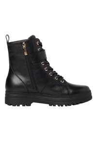 Bottines en cuir noir avec des œillets dorés, une fermeture éclair sur le côté et une semelle en caoutchouc épaisse. Présentent une sangle à l'avant pour plus de détail.