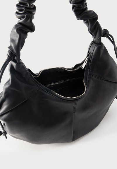 Black leather handbag with ruched handle, open zipper showing interior pocket and smooth exterior surface.