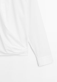 Hvid button-up skjorte, langærmet, lavet af glat stof, med spids krave, skjult knaplukning og let draperet design.